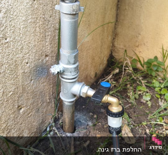 ברז מים מותקן על קיר עם צינור